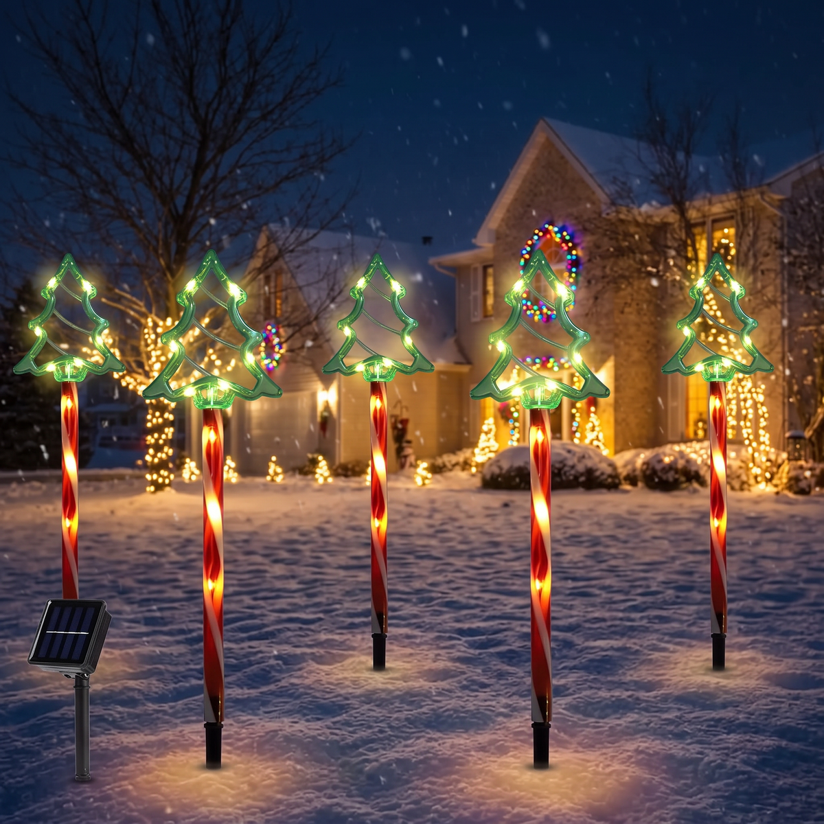 Solar Christmas tree lights glowing in a snowy yard
