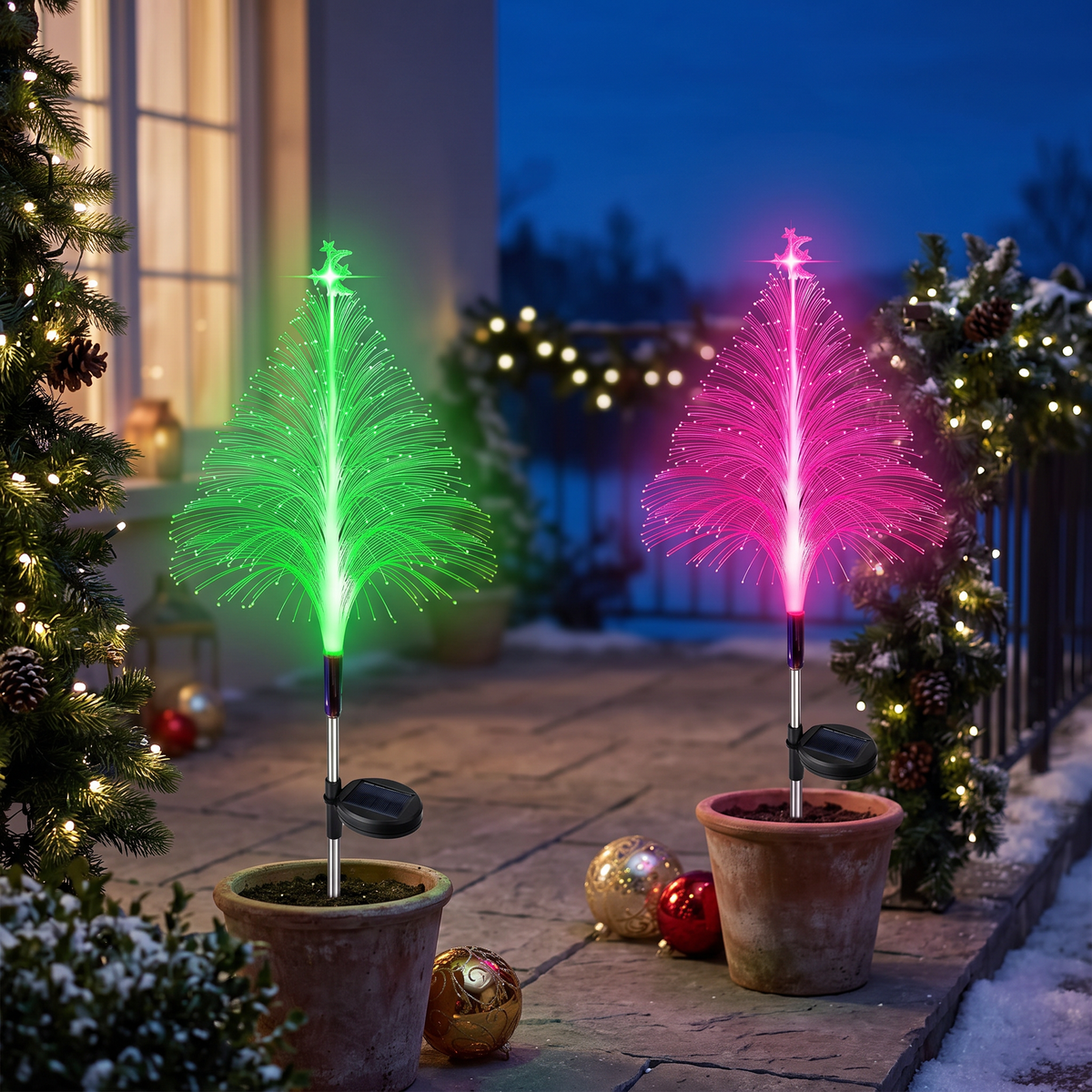 Both color-changing solar tree lights on a patio at twilight