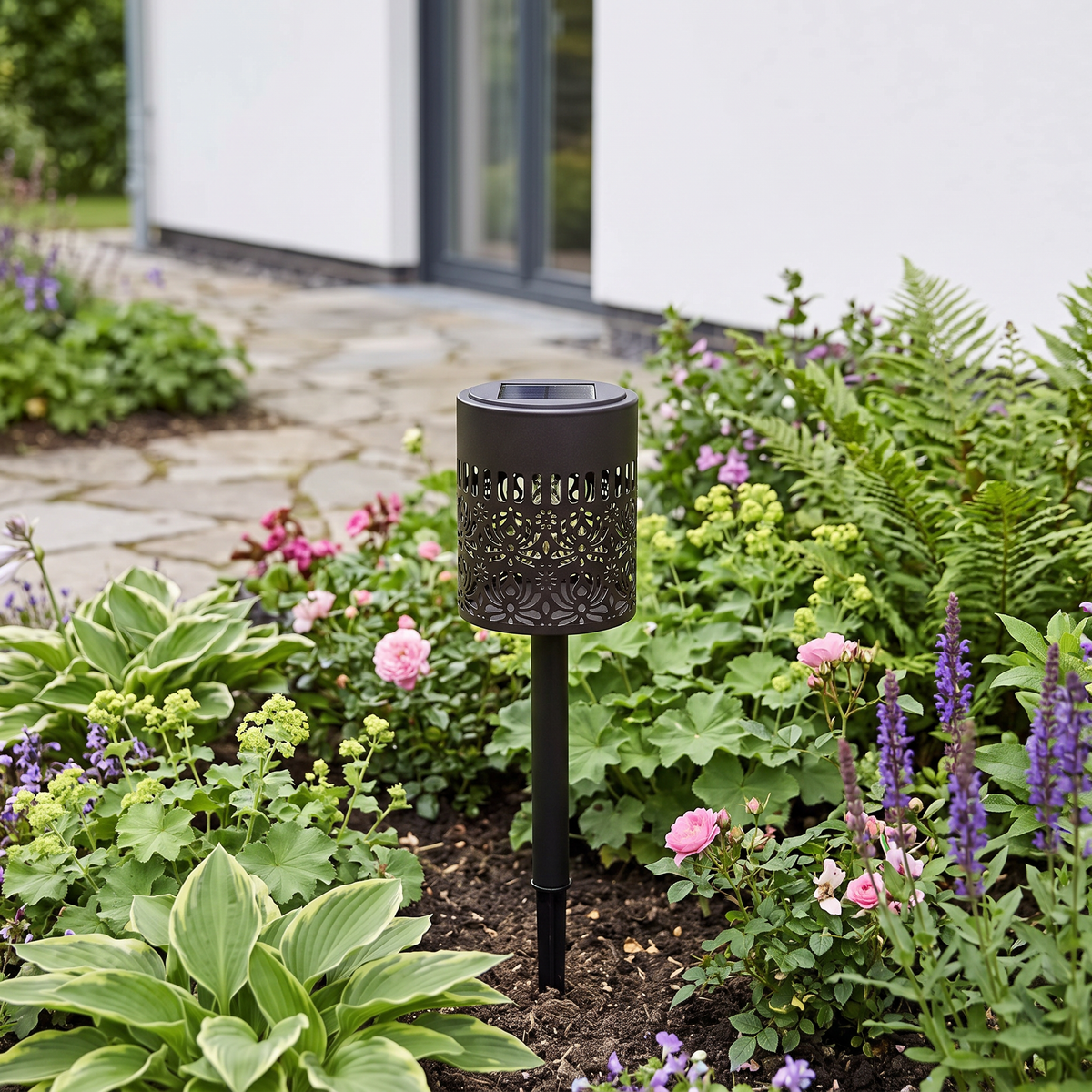 Peony mandala solar light in a flower bed in daylight