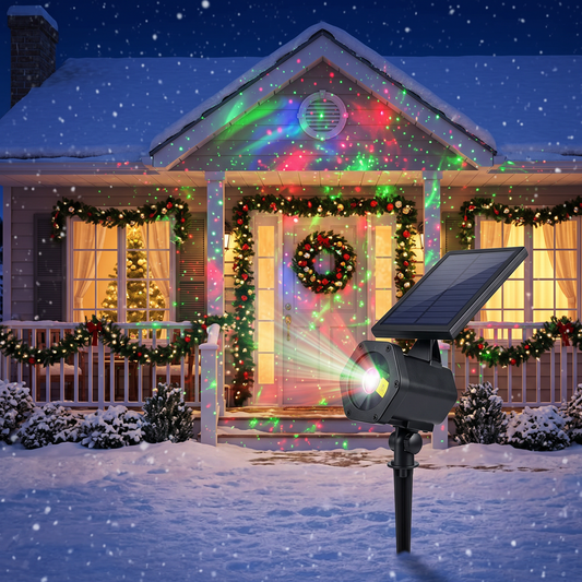 Projector lighting a decorated house on a snowy evening